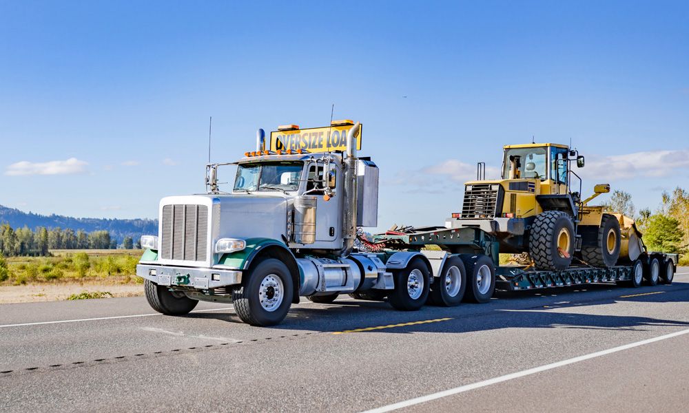 RGN trailer transporting heavy duty commercial tractor